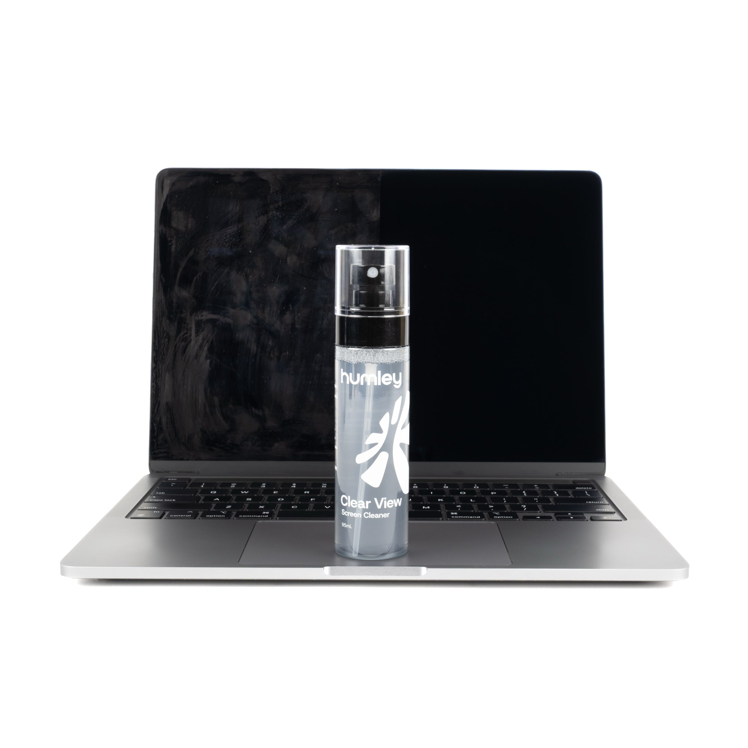 Humley Clear View Screen Cleaner placed in front of a MacBook showing a split screen—dirty on the left and clean on the right.