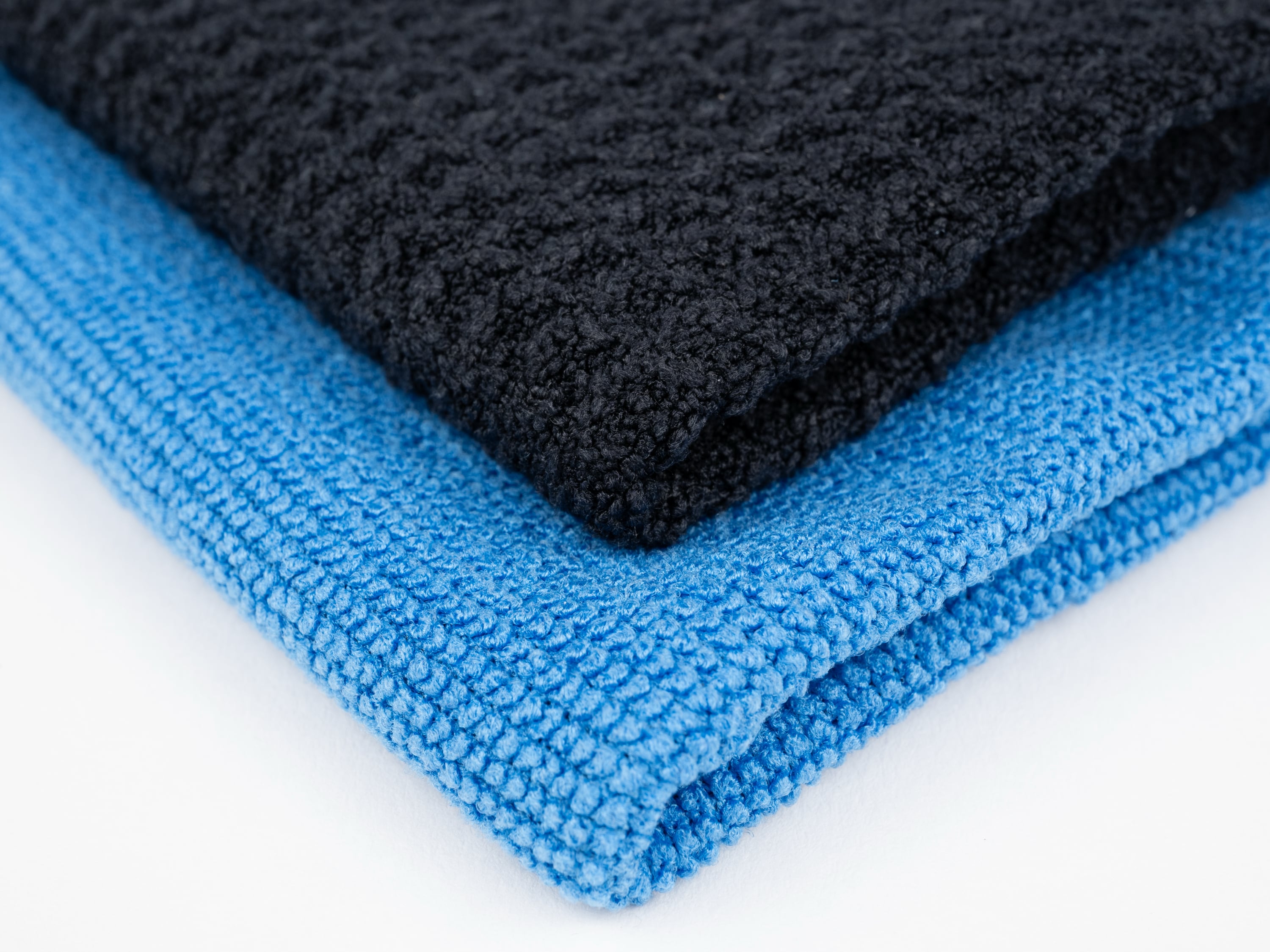 Close-up of black and blue microfiber cleaning cloths with textured weave.