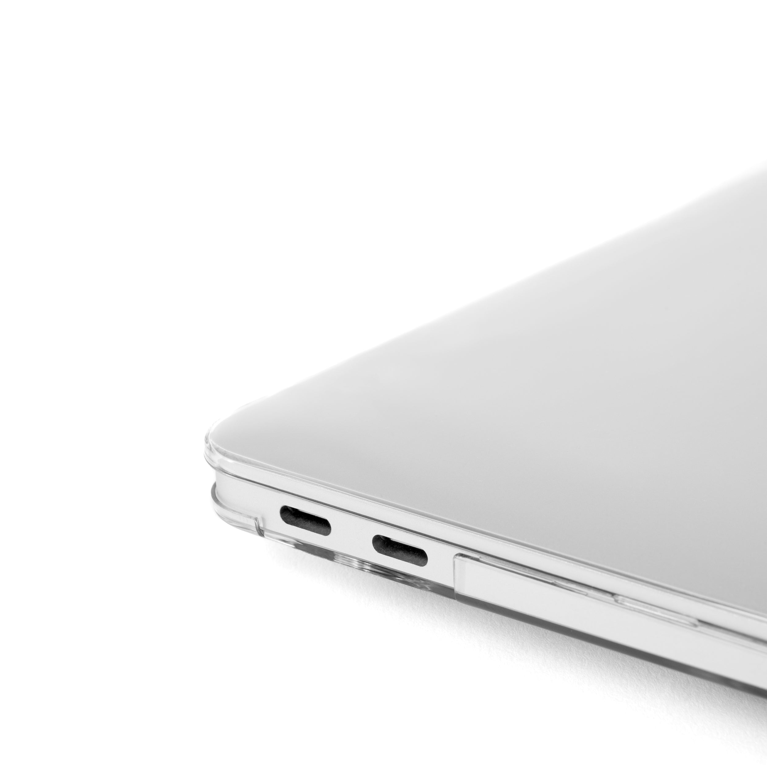 Close-up of MacBook Pro 14-inch corner with Humley clear hard case showing snug fit and USB-C port access