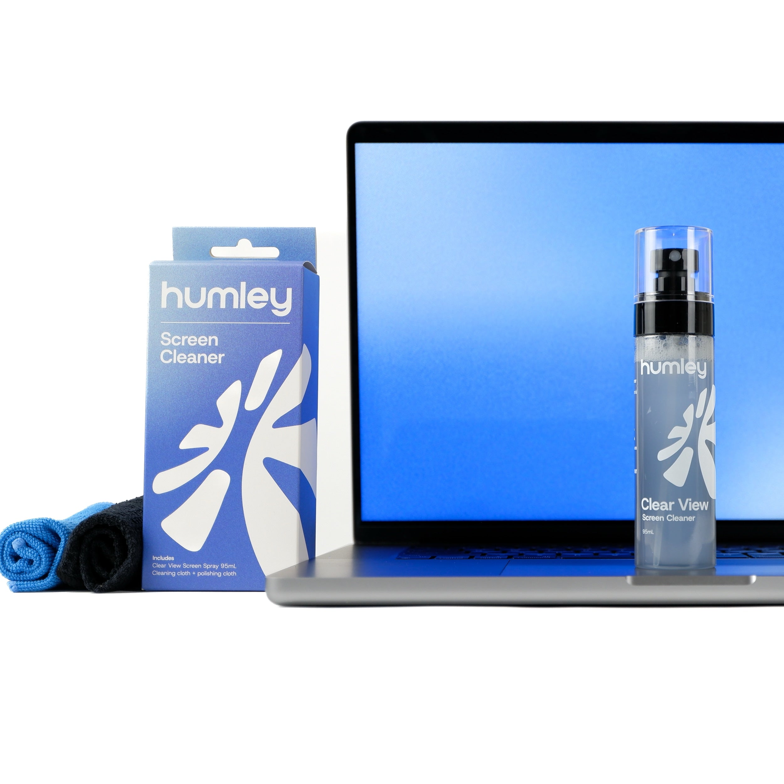 Humley Clear View Screen Cleaner bottle, box, and cloths displayed in front of a MacBook with a blue screen.